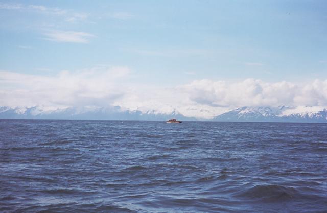 A look across to another boat in search of halibut with the lower mountains of the Alaska Range serving as a backdrop.